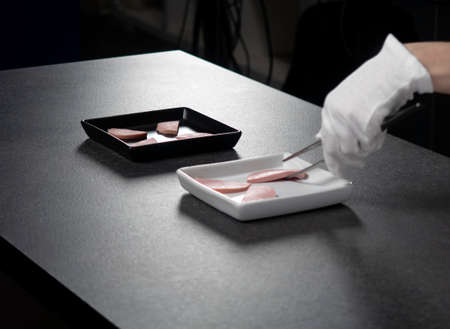 female hands in white cloth gloves on a dark background