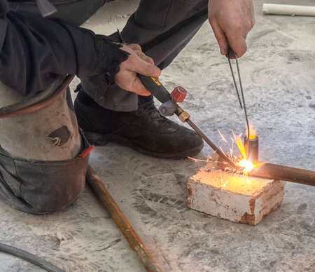 welding metal pipe by acetylene gas burner close up.