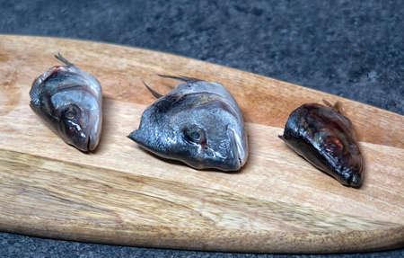 Raw fish. Fish prepared for cooking. Fish and spices on a wooden table.