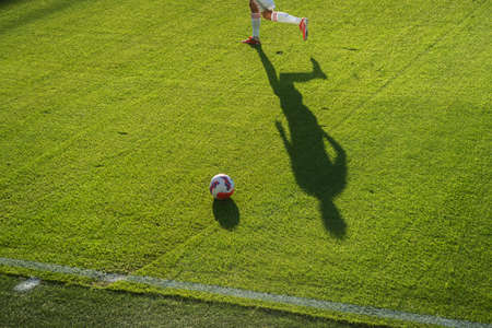 soccer players kicking football ball. Man play soccer on sports field.の写真素材