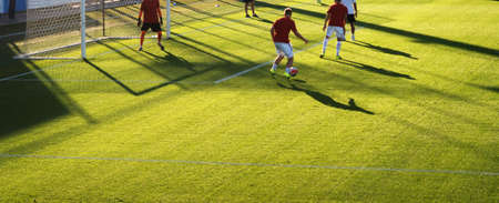 soccer players kicking football ball. Man play soccer on sports field.の写真素材