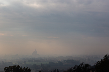 Moody view of S.M. degli Angeli church (Assisi, Umbria, Italy) in the midst of autumn mistの写真素材