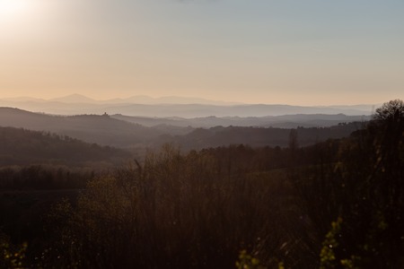 Beautiful view of Tuscany hills at sunset, with mist and warm colors