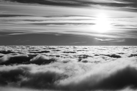 Beautiful sunset over a valley filled by fog with mountains and hills