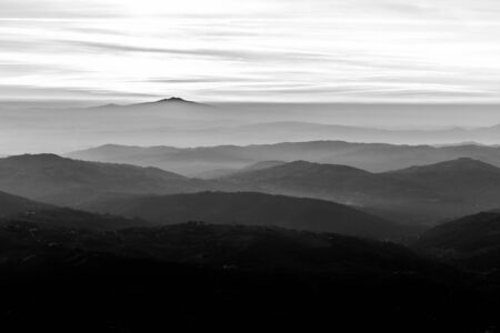 View of Umbria valley at dusk with layers of hills and mountains in the middle of mist
