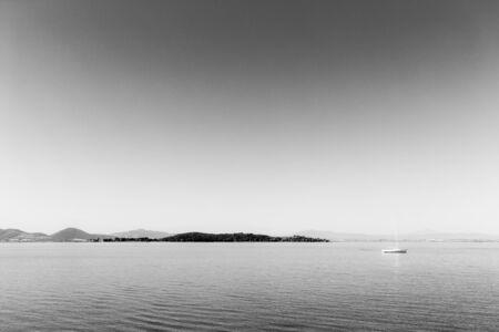 Small boat sailing on Trasimeno lake, Italyの写真素材