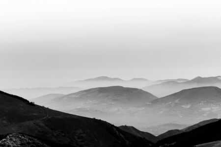 Dusk, with mountains layers and mist between them.の写真素材