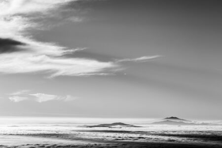 Distant mountains above a sea of fog like an islandの写真素材