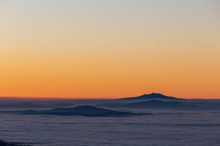 Distant mountains above a sea of fog like islands.の写真素材