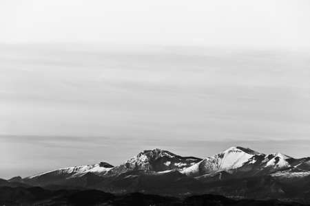 View of distant mountains peaks covered by snowの写真素材