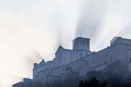 St Francis church in Assisi (Italy) projecting shadows in the mist