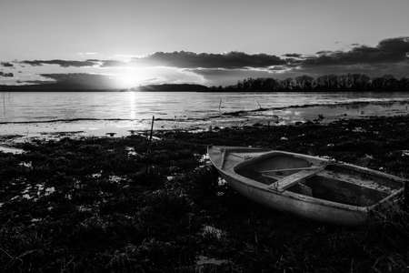 View of shore of Trasimeno lake Umbria, Italy with a little boat at sunsetの写真素材