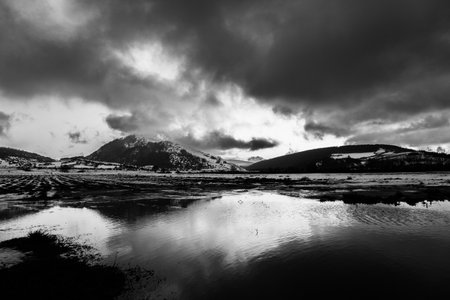 Perfectly symmetric clouds and hills reflections on Colfiorito Umbria swampの写真素材