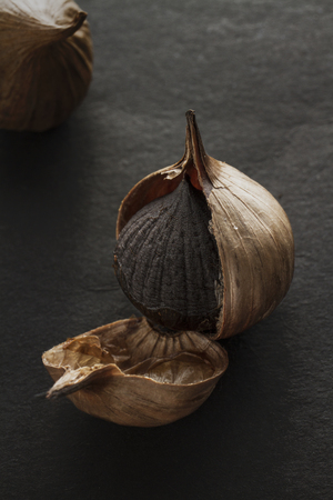 Black garlic clove on black paper backgroundの写真素材
