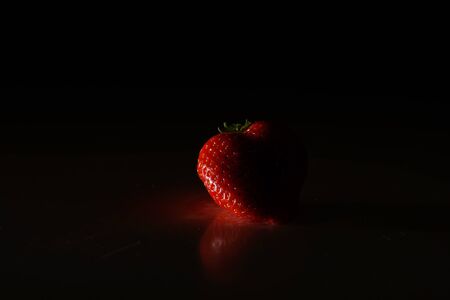 Fresh organic strawberries isolated on a black background. Packaging made from organic strawberries.の写真素材