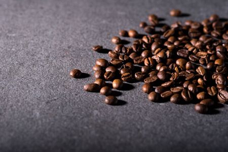 Roasted coffee beans on a stone background. Coffee beans texture. Coffee in beans on dark background. Food background of coffee beans. Abstract background texture.の写真素材
