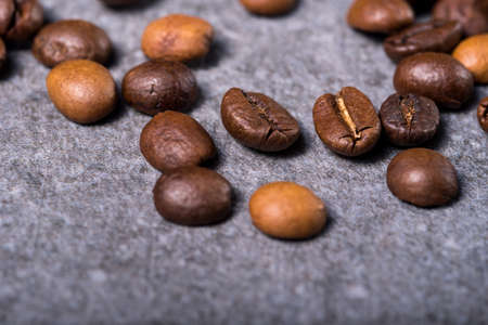 Roasted coffee beans on a stone background. Coffee beans texture. Coffee in beans on dark background. Food background of coffee beans. Abstract background texture.の写真素材
