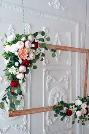 Wooden frame decorated with artificial flowers. wedding composition. Flowers on a stand.