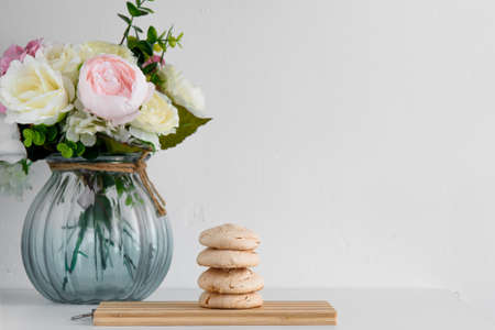 The meringue is stacked on a light board. Meringue on a light background. Blue vase with flowers.の写真素材