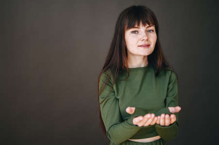 On a black background, a portrait of a girl with outstretched arms forward. The concept of asking