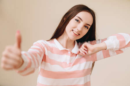 Cute girl with brown hair shows cool, smiles broadly. Photo in warm processing. close-up portraitの写真素材