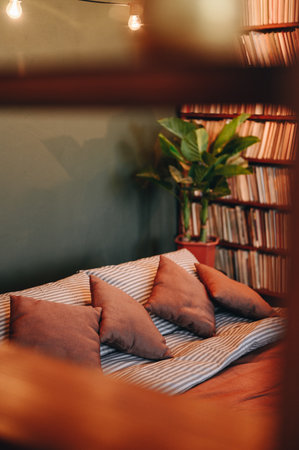 Loft bedroom interior, pillows laid out beautifully in the bed. Close-up made bed, top view vertical photographyの写真素材