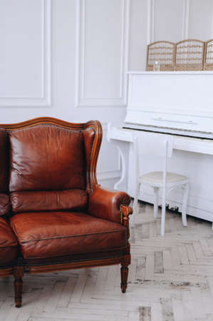 Vertical photo of a photo studio, cropped frame of the interior. Sofa on the background of a white...