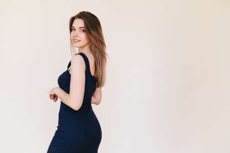 Beautiful Slender Young Woman in Black Fitted Classic Dress on Beige Background. Girl with Perfect...