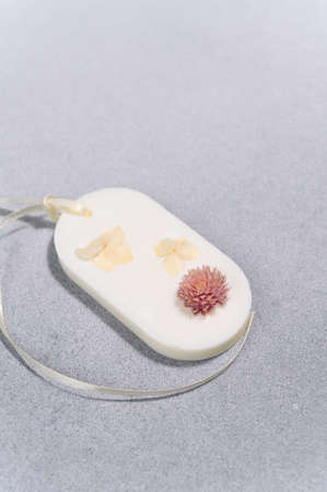 Florentine Sachet with Dried Yellow Escholcia and Gomphrena Flowers. Side View Closeup Handmade. Vertical Photo of Product Shot of an Aromatic Wax Sachet. side light.の写真素材