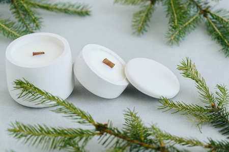 Handmade Candles in Gypsum Mold with Wooden Wick Among Christmas Tree Branches. Christmas Theme,...