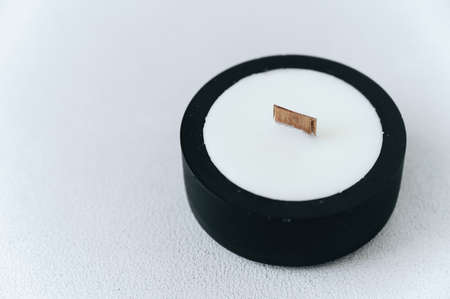 White Soy Candle in Black Plaster with Wooden Wick on Concrete Clean Background. On Left is Free Space for Text. Concept Flat Lay of Candles.の写真素材