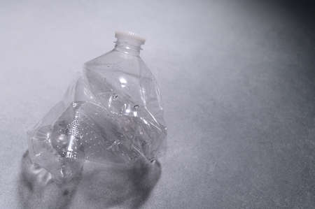 Crumpled Plastic Bottle on Light Wall. Recycling of Garbage, Plastic. Ecological Problem, Global Environment. Top View, Flat Lay.の写真素材