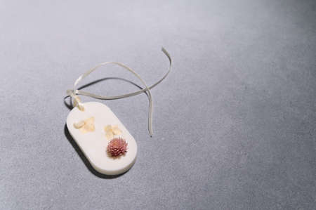 Flat lay of one Florentine Aromatic Sachet with Dried Flowers in Shape of an Oval on Gray...