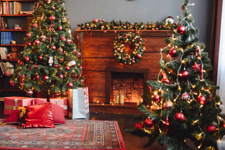 Christmas Red Interior. Hall is Decorated with New Year's Decor. Christmas Tree and Fireplace. Cozy and Beautiful Day on Eve of Holiday.の写真素材