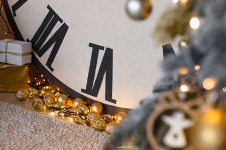 Golden New Year's Toys lie on Floor with Garland. Clock Element with Christmas Theme.