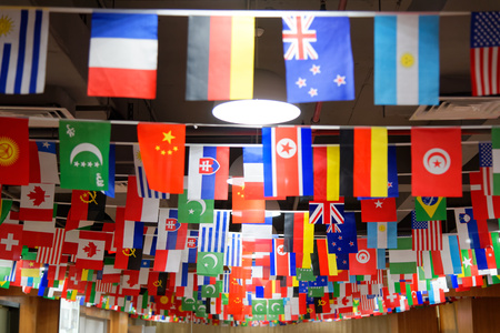 Many countries flags hanging from a ceiling on ropes