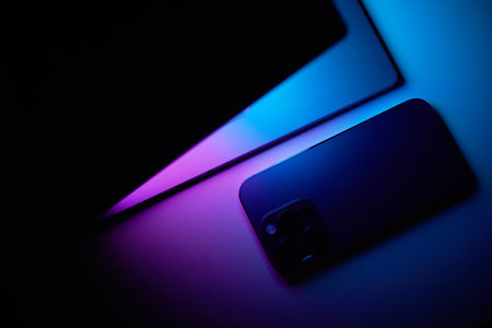 Laptop with smartphone. Neon dark light.の写真素材