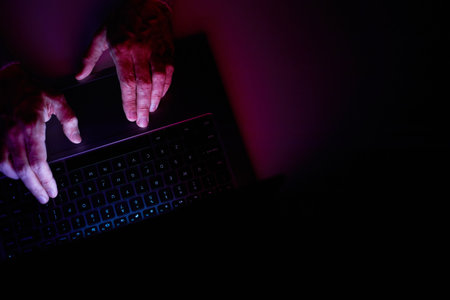 Male hands are typing on a laptop keyboard. A man works, develops a business, studies, plays a...