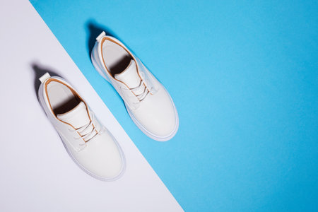 Trendy leather female sneakers. White milky color, paper color backgroundの写真素材