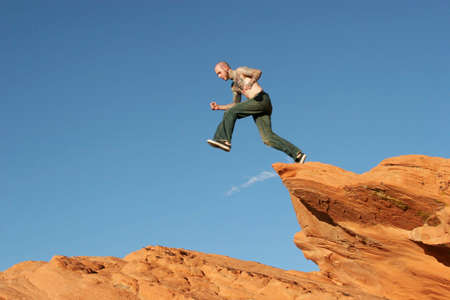 Man jumping on red rocksの写真素材