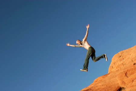 Man jumping on red rocksの写真素材