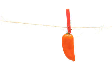 Orange pepper hanging on a rope