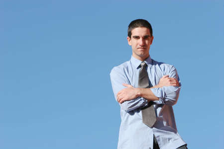 Confident businessman against blue skyの写真素材