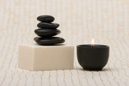 Spa stones and a bar of soap with lit candle