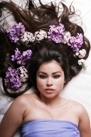 Beautiful woman with flowers on her hairの写真素材
