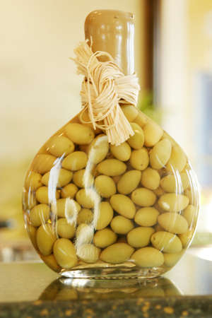 Green olives in decorative glass bottleの写真素材