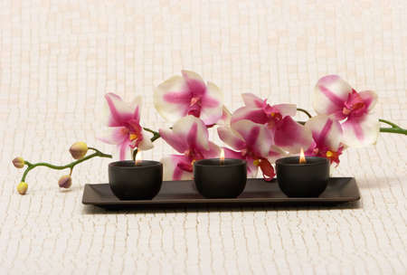 Aromatherapy candles and pink orchidの写真素材