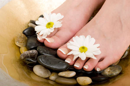 Woman's feet in bowl of water and rocksの写真素材