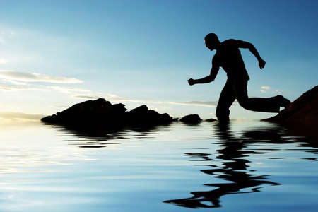 Silhouette of a man walking down hillの写真素材