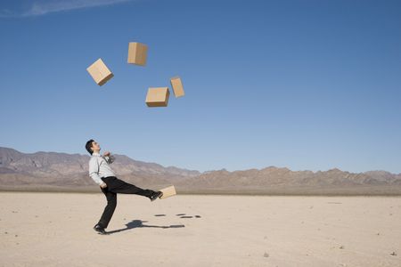 Businessman kicking boxes in the airの写真素材
